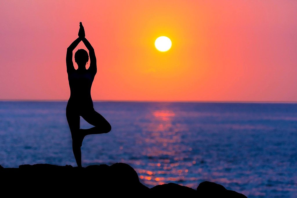 Woman in Tree Pose at Beach in Sunset